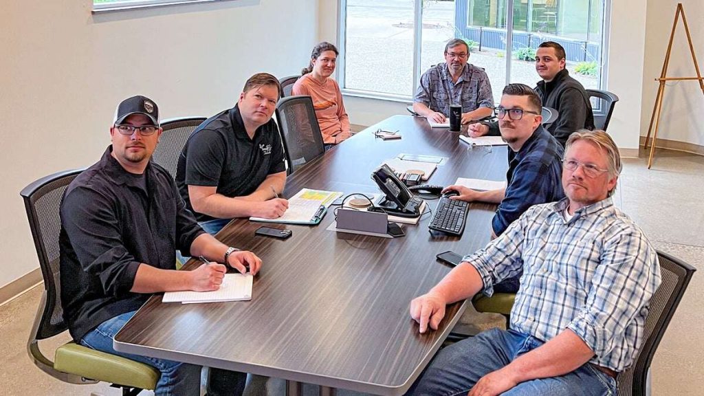 Eagle CNC staff conducting their daily production meeting with a cross functional team environment in the conference room